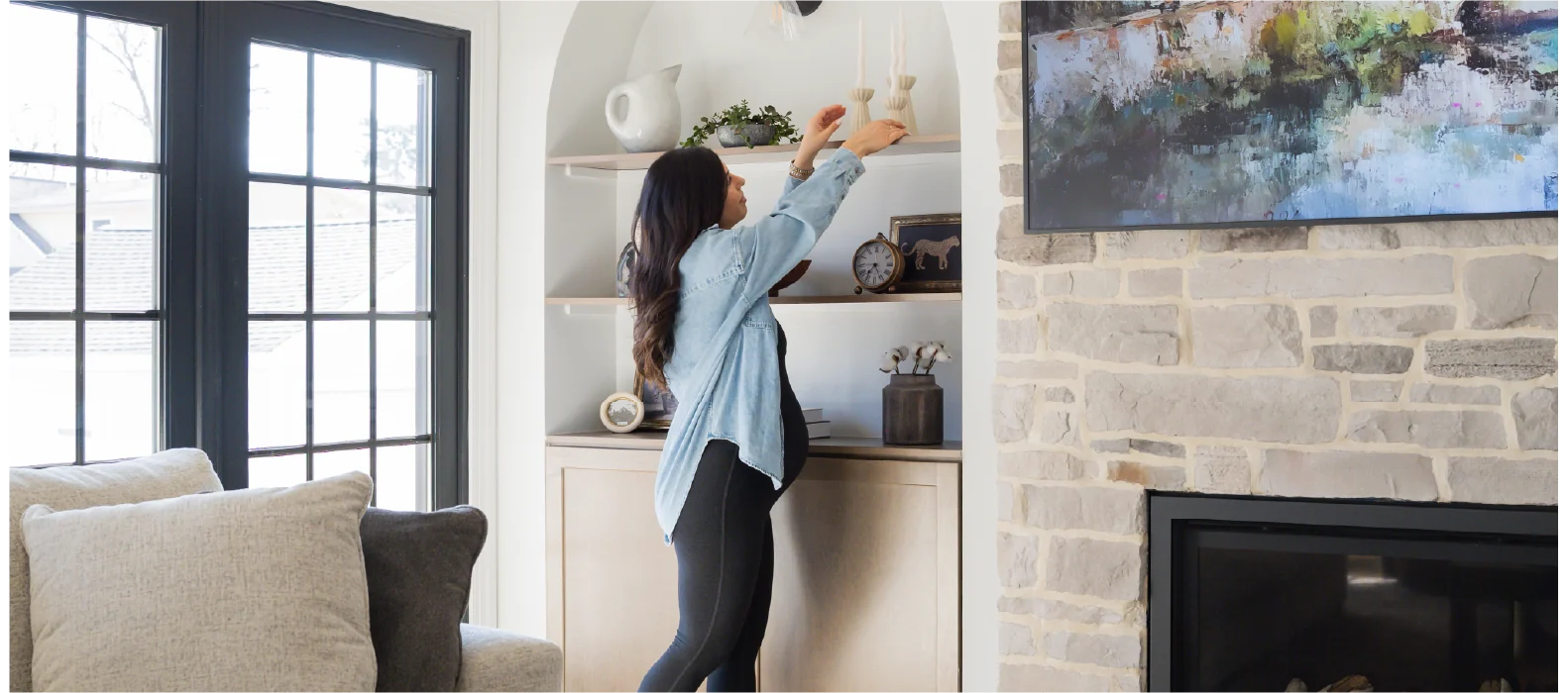 A bright living room and styled fireplace scene